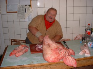 Der Metzger Hausi (selig) mit einem Schweinekopf